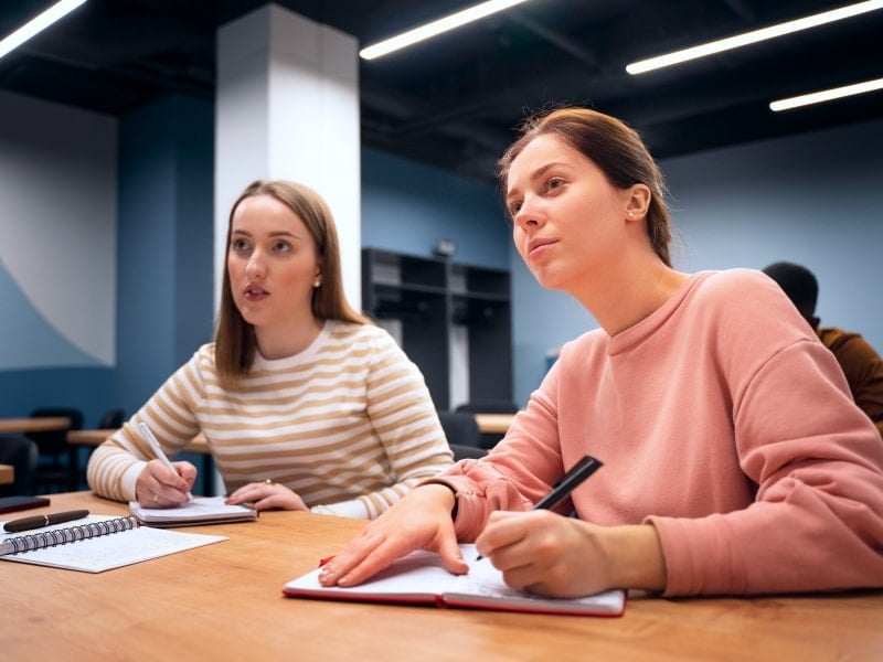 Two Girls Listening to The Class